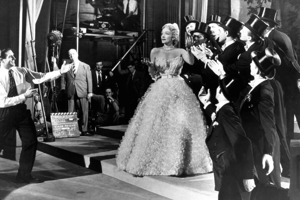 Marlene Dietrich en Stage Fright, vestida de Dior. Al fondo, Alfred Hitchcock.
