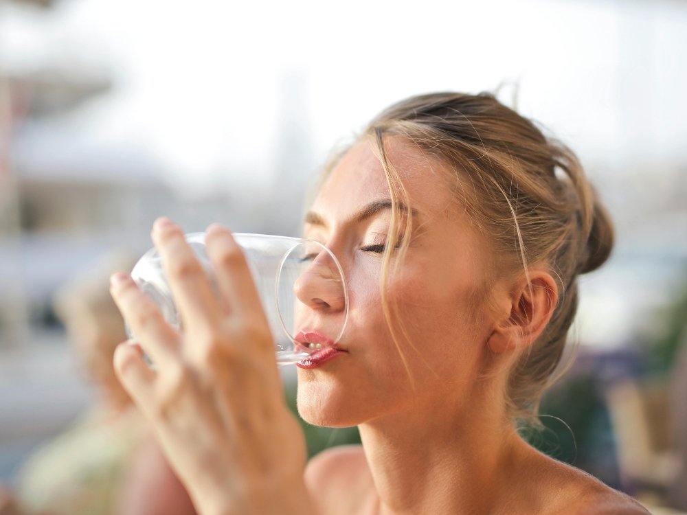 Mujer tomando agua tips para oler bien